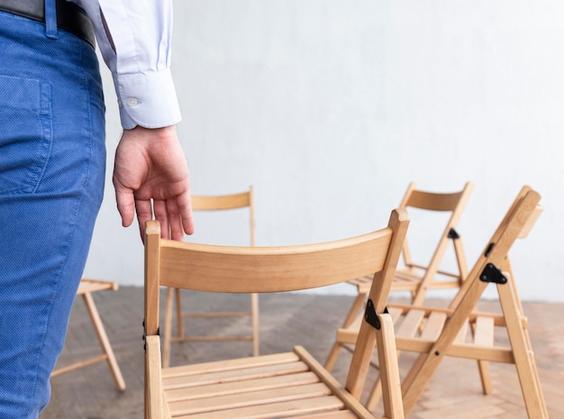 Back view of person with empty chairs prepared for group therapy