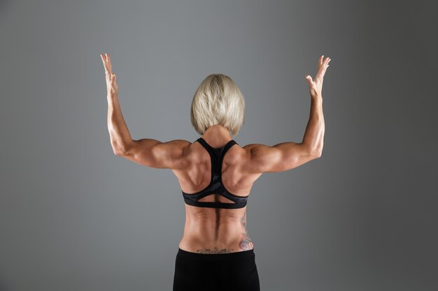Back view portrait of a muscular strong sportswoman