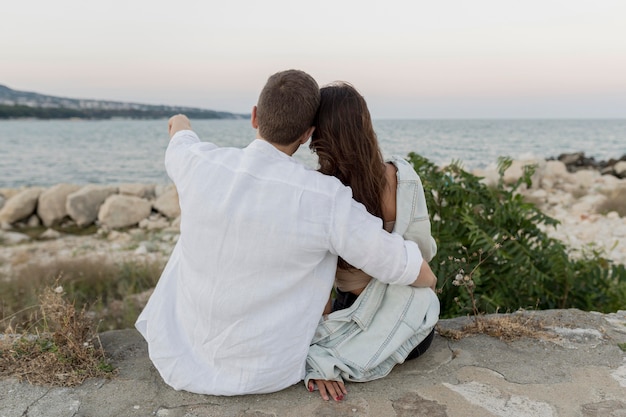 Foto gratuita vista posteriore della coppia romantica abbracciata dall'oceano