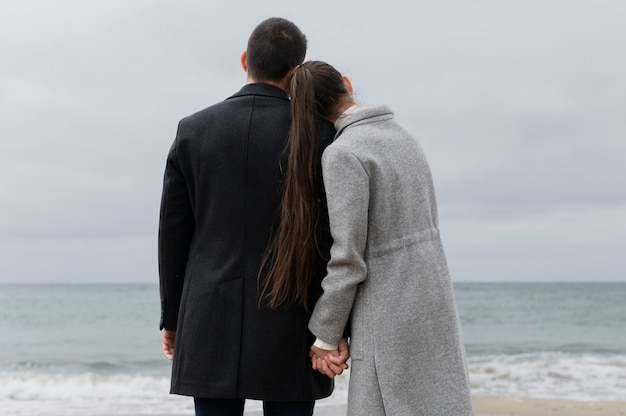 Free photo back view romantic couple holding hands