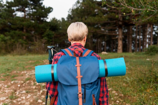 Free photo back view of senior tourist woman in nature