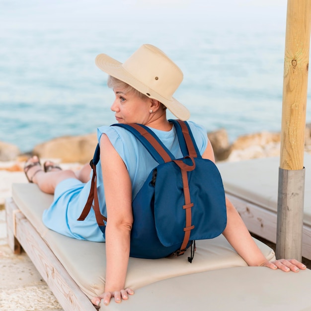 Foto gratuita punto di vista posteriore della donna turistica senior con lo zaino