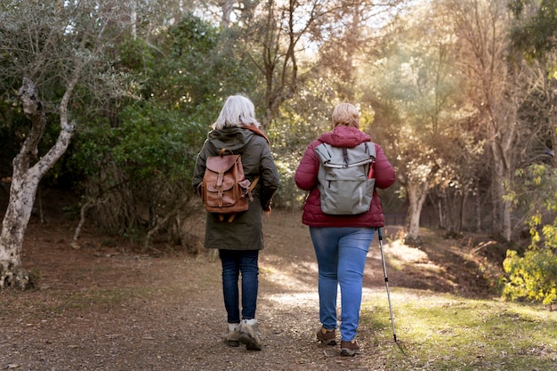 Вид сзади на пожилых женщин, наслаждающихся прогулкой на природе