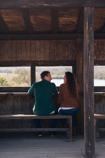 Free photo back view sitting couple inside a shelter