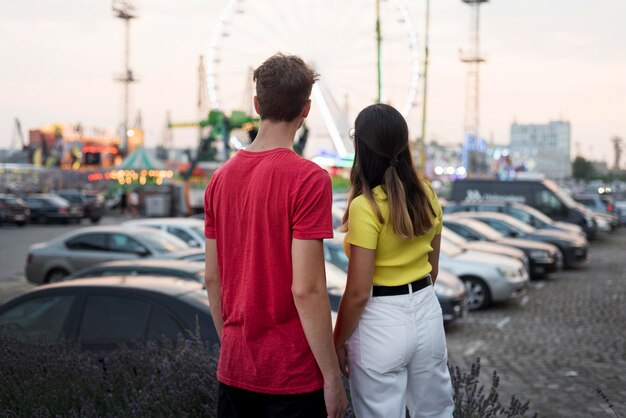 Back view teenagers looking at amusement park