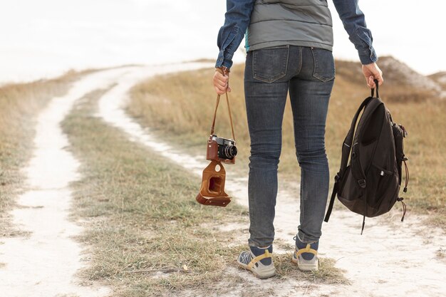 Back view traveler holding backpack