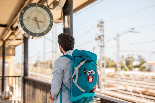 Back view traveler looking at clock