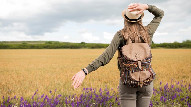 Back view traveller with hat and backpack