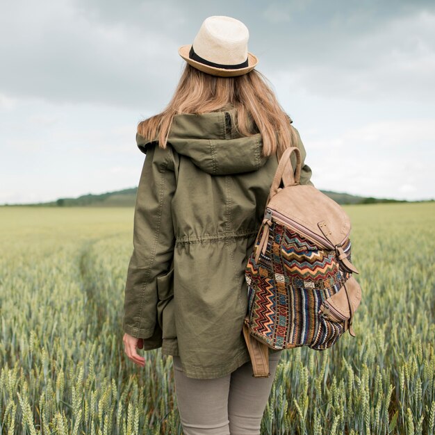 Back view traveller with hat and backpack