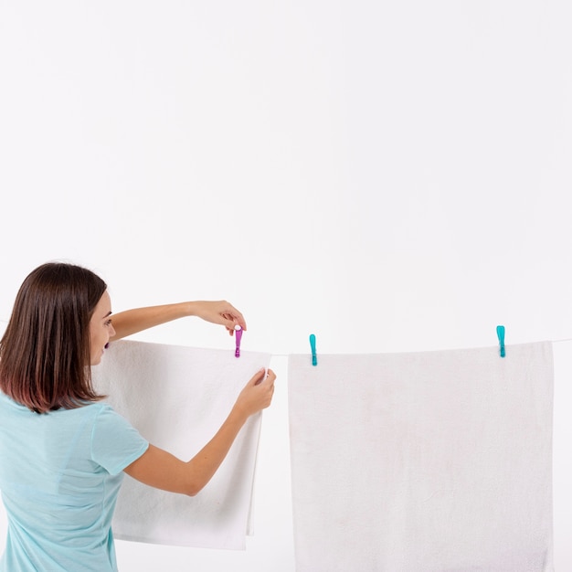 Back view woman arranging towels on clothesline