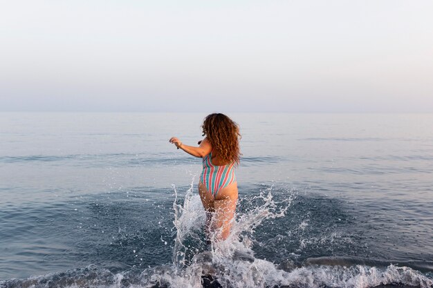 水に行くビーチで女性の背面図