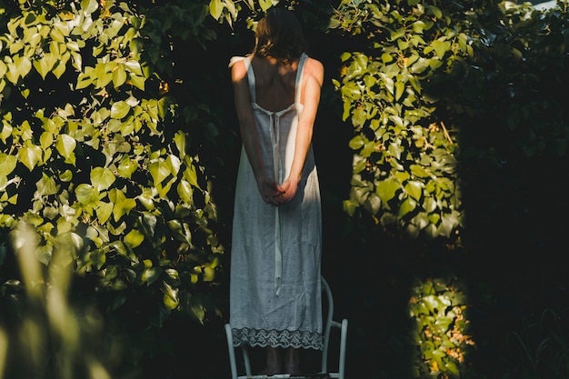 Back view woman on chair in garden