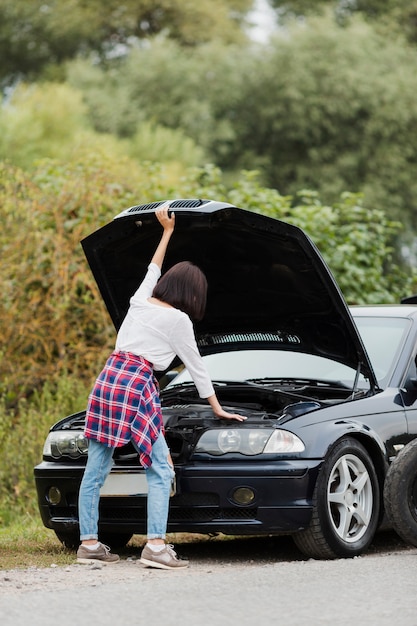 Free photo back view of woman checking engine