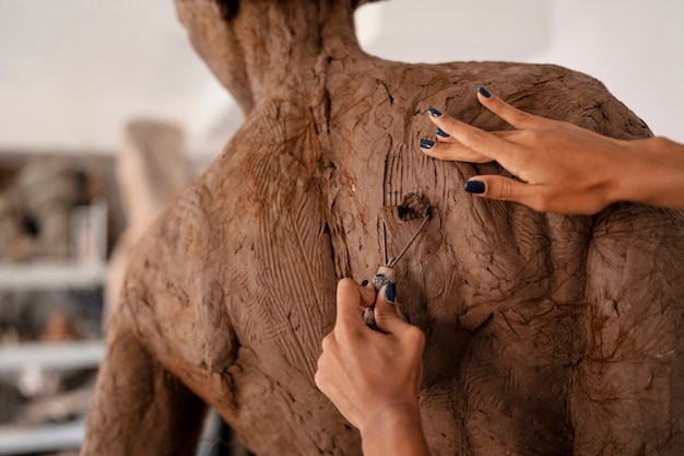 Foto gratuita scultura dell'argilla della donna di vista posteriore