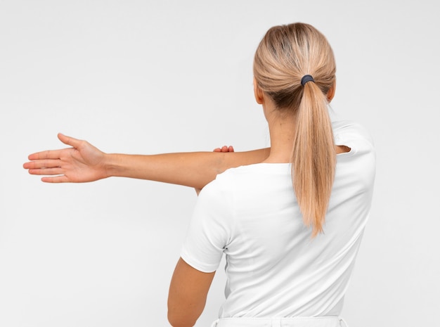 Free photo back view of woman doing physiotherapy exercises