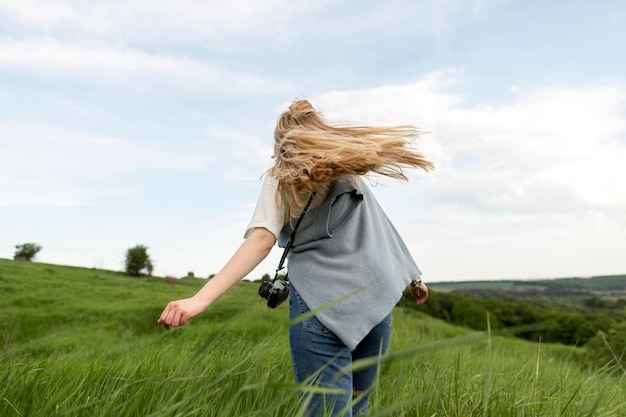 Punto di vista posteriore della donna che gode dell'aria fresca in natura