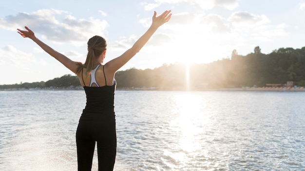 Foto gratuita donna di vista posteriore che gode della luce del sole