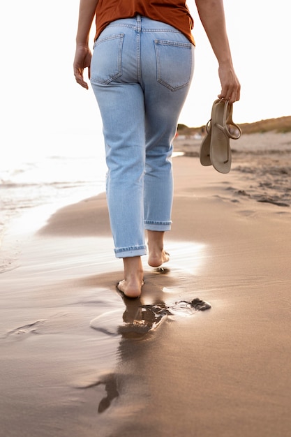 Back view of woman enjoying a walk by the beach