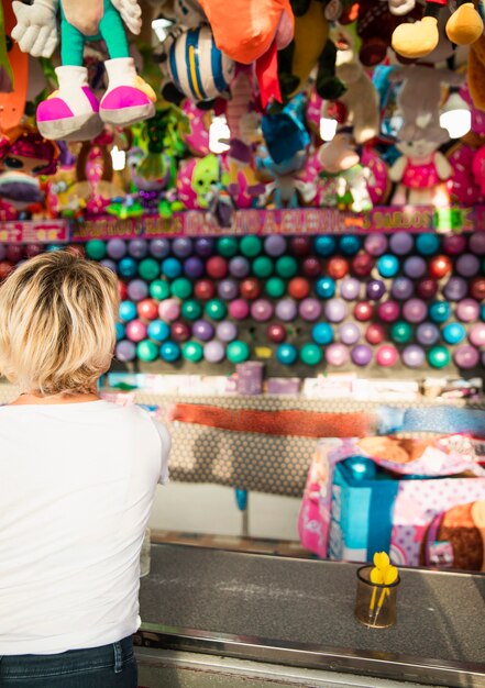 Back view woman at festival game stand