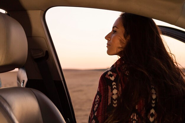 Вид сзади женщины, выходящей из машины, чтобы насладиться природой