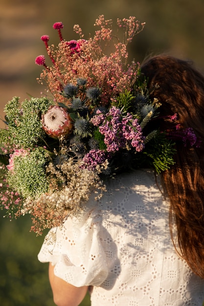 Back view woman holding beautiful flowers