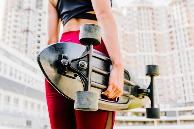 Back view of woman holding a longboard