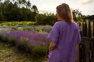 Foto gratuita donna di vista posteriore che esamina il campo di lavanda