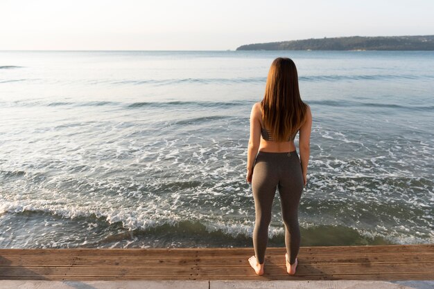 Back view woman looking at the sea with copy space