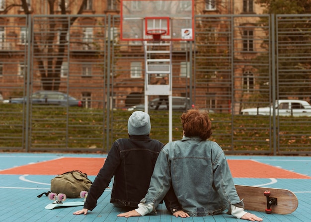 Back view woman and man looking at a basketball field