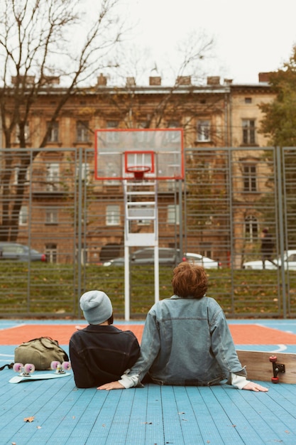 バスケットボールのフィールドを見ている女性と男性の背面図