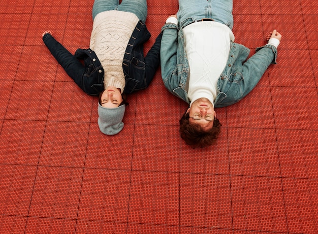 Free photo back view woman and man lying on a basketball field together