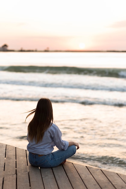 Back view woman meditating outdoors