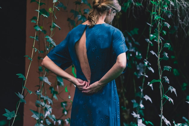 Free photo back view woman near house with ivy