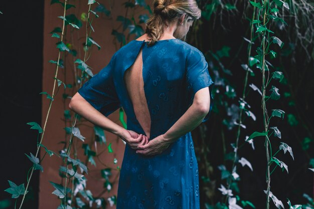 Back view woman near house with ivy