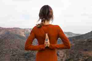 Free photo back view of woman outdoors in nature in yoga pose