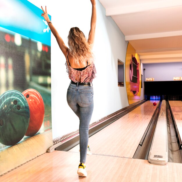 Back view woman playing bowling