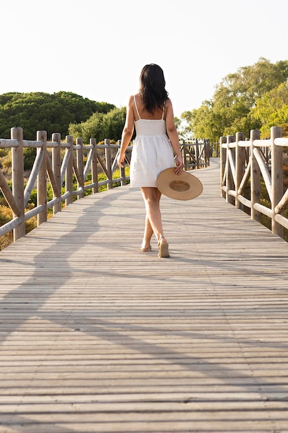 Back view of woman posing on bridge in nature