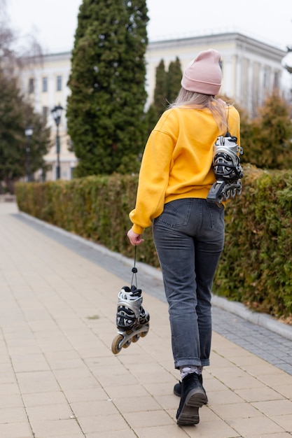 女性がローラーブレードを押しながらポーズの背面図