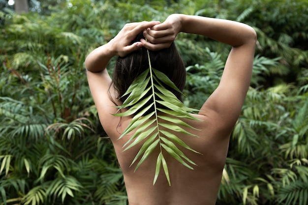 Back view woman posing with leaf