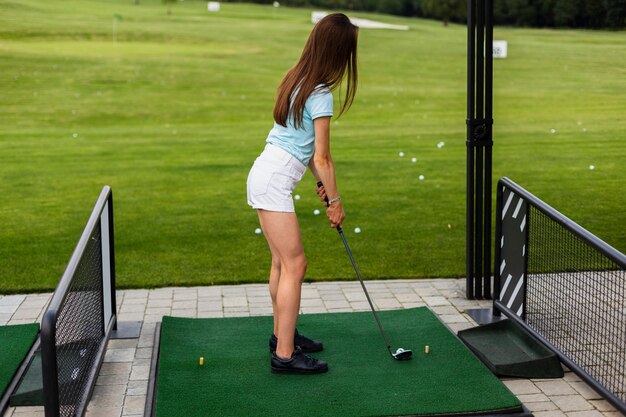 Back view of a woman practicing golf