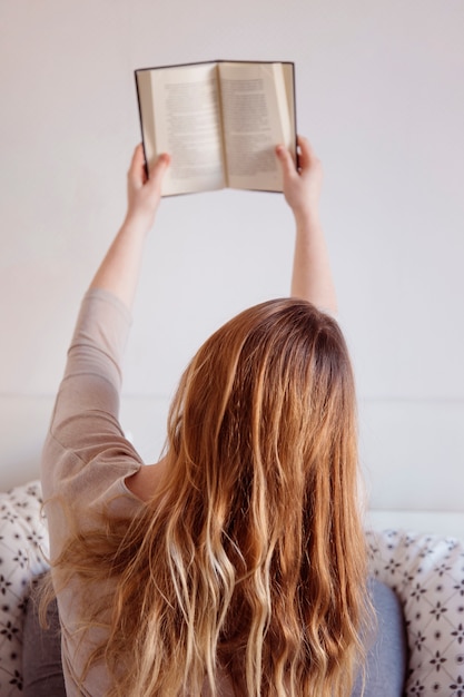 Foto gratuita libro di lettura della donna di vista posteriore