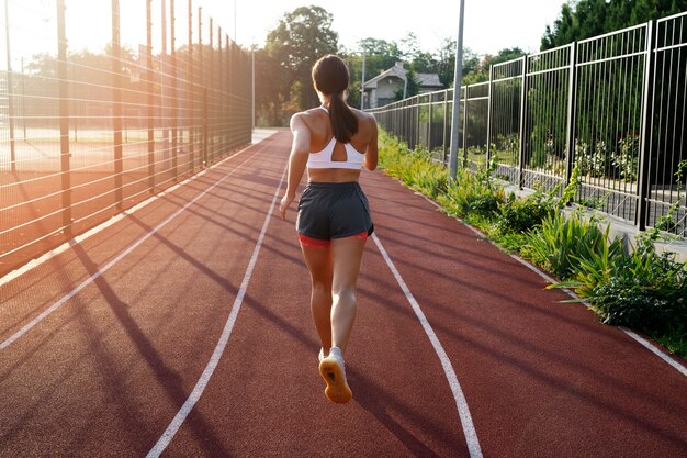 Back view woman running on track