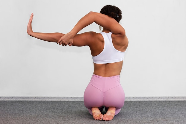 Free photo back view woman showing flexibility