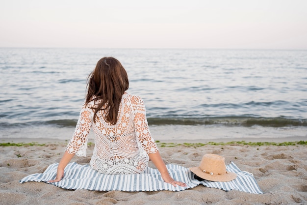 Back view woman sitting on blanket