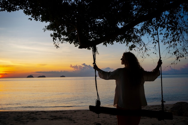 Free photo back view woman sitting on a swing