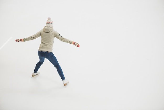 Free photo back view woman skating on rink