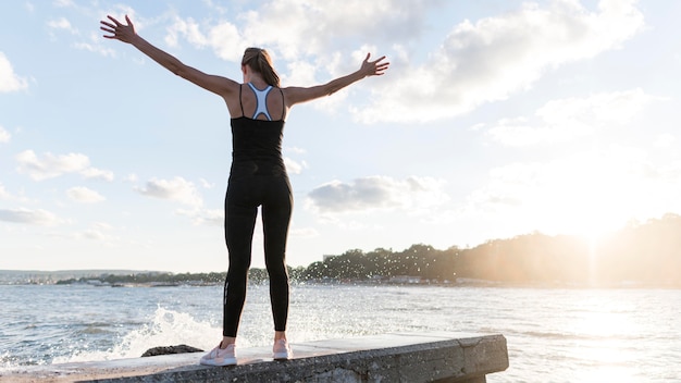 Free photo back view woman standing in a victorious way with copy space