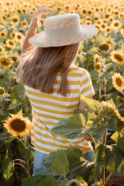 Back view woman in sunflower field