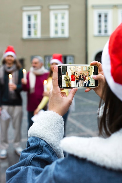 Back view woman taking photos with smartphone