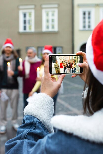 Вид сзади женщина фотографирует со смартфоном